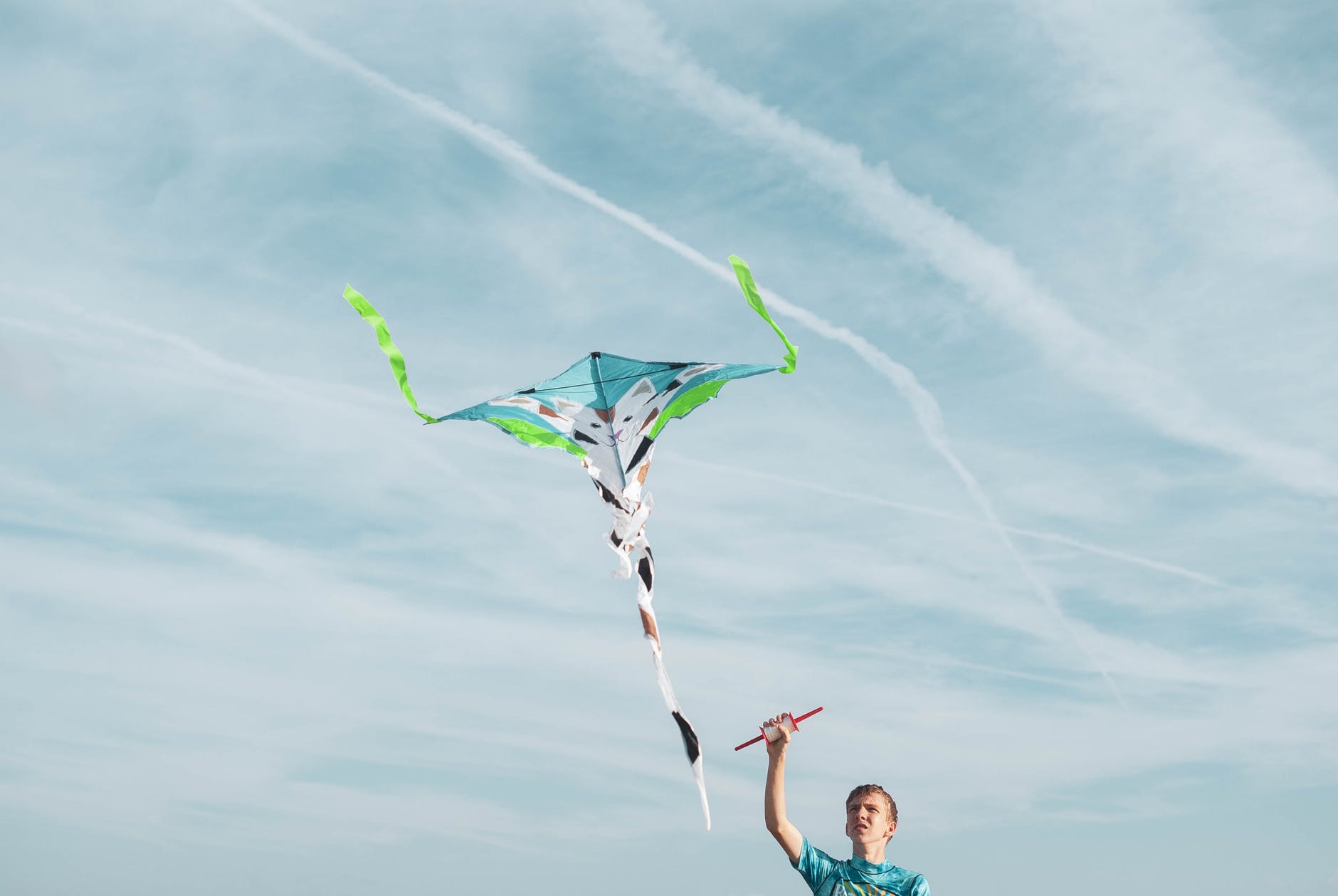 man wearing blue shirt flying kite