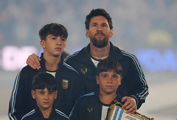 Lionel Messi of Argentina and his children,Thiago Messi, Mateo Messi and Ciro Messi line up on the pitch